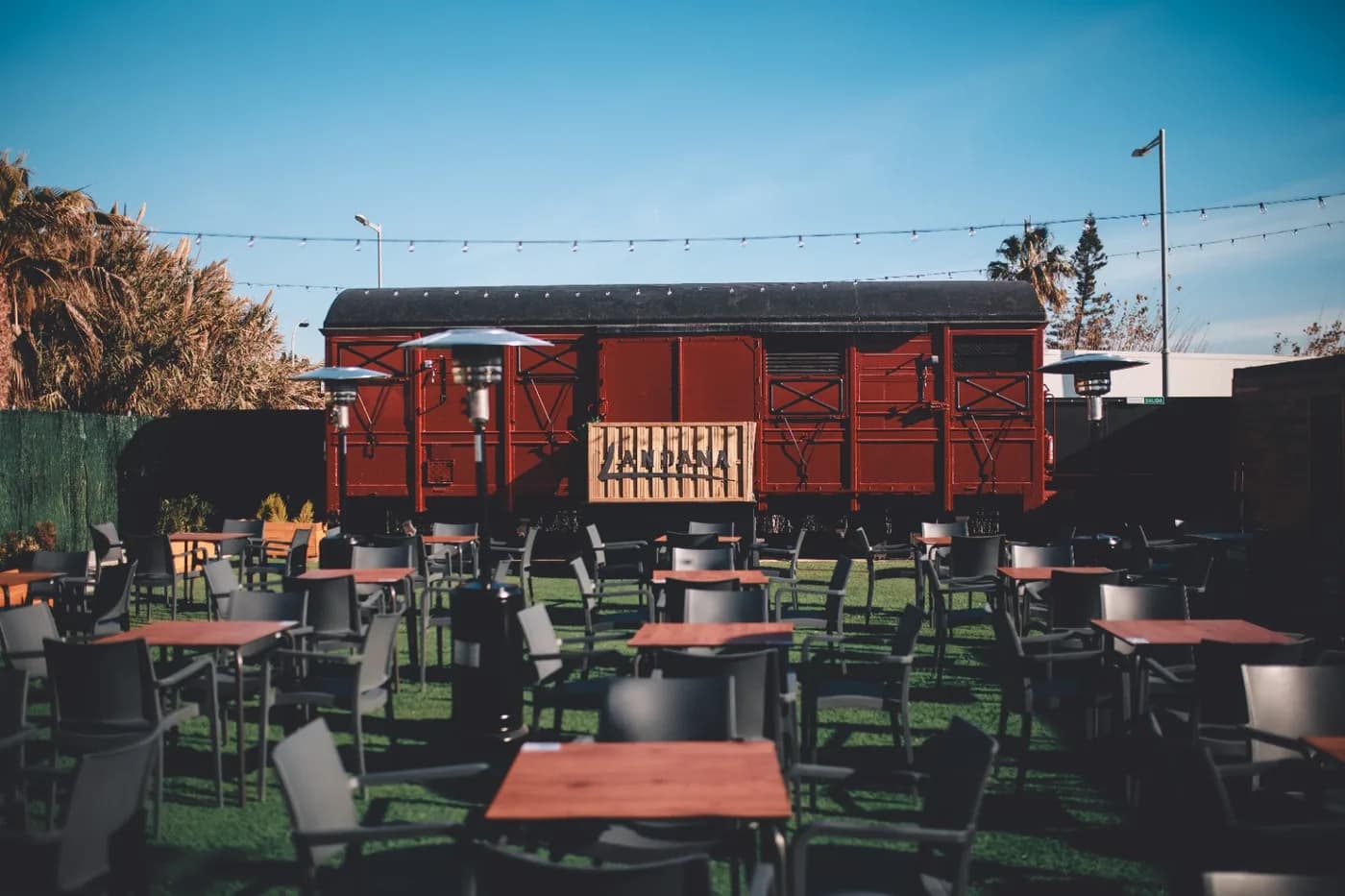 El vagó de tren restaurat de Landana, amb les taules del jardí al davant.